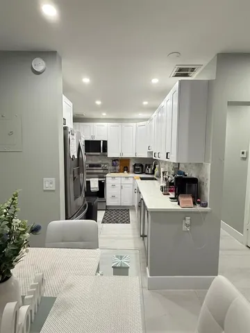 a living room with kitchen island furniture and a kitchen view