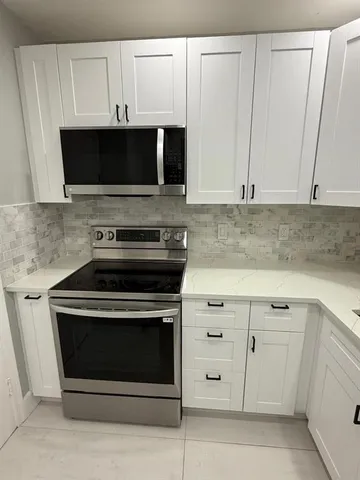 a kitchen with stainless steel appliances a stove a microwave and cabinets