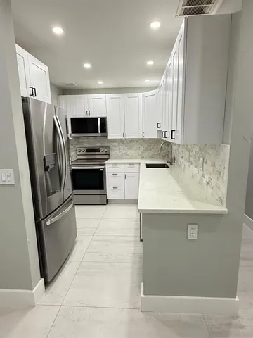 a kitchen with stainless steel appliances granite countertop a refrigerator stove and sink