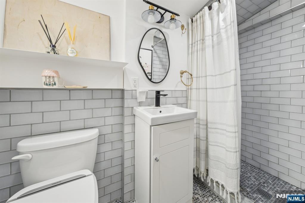 208 Jefferson Avenue Hasbrouck Heights, NJ 07604 - Photo 12 of 20 a bathroom with a toilet sink mirror and vanity