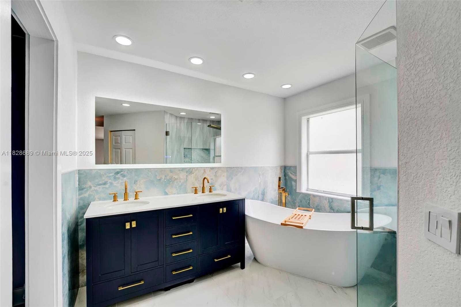 275 Southwest 198th Terrace Pembroke Pines, FL 33029 - Photo 27 of 35 a bathroom with a bathtub a double vanity sink a window and mirror