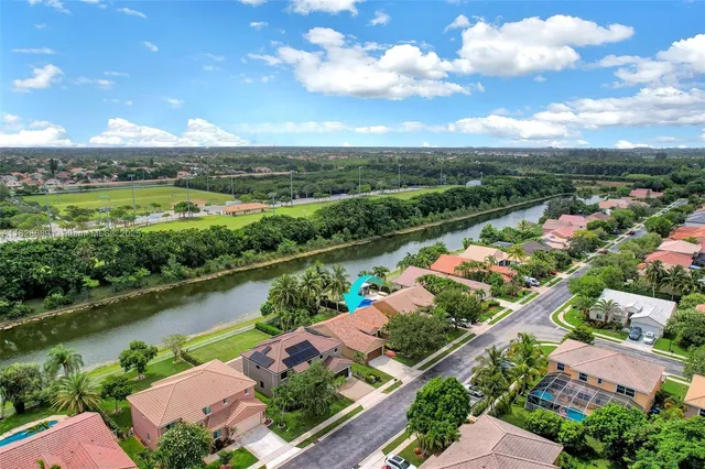 an aerial view of a house with a garden and lake view