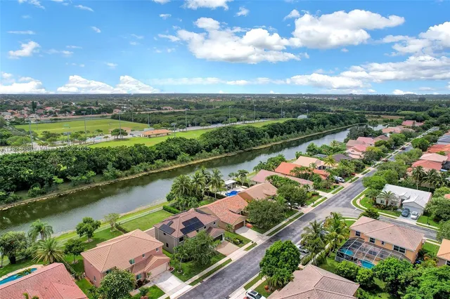 an aerial view of a house with a garden and lake view