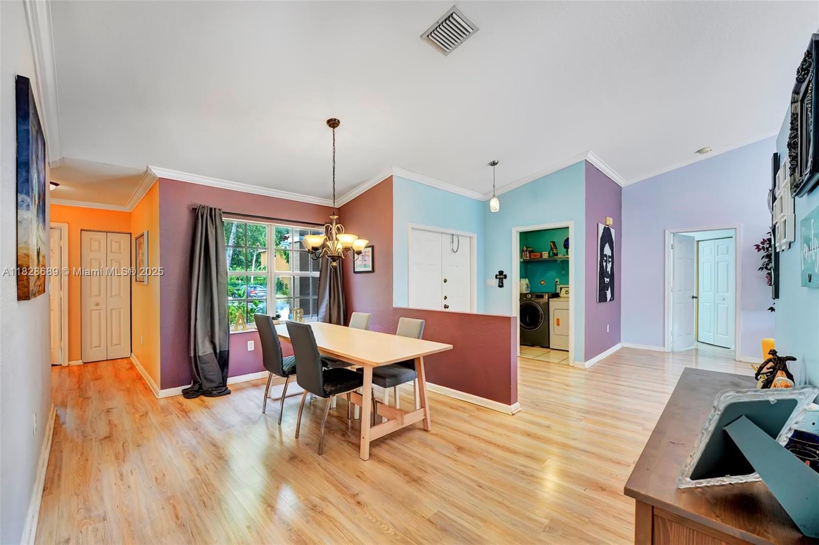 275 Southwest 198th Terrace Pembroke Pines, FL 33029 - Photo 10 of 35 a dining room with wooden floor a chandelier a glass table and chairs
