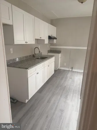 a kitchen with granite countertop a sink and cabinets