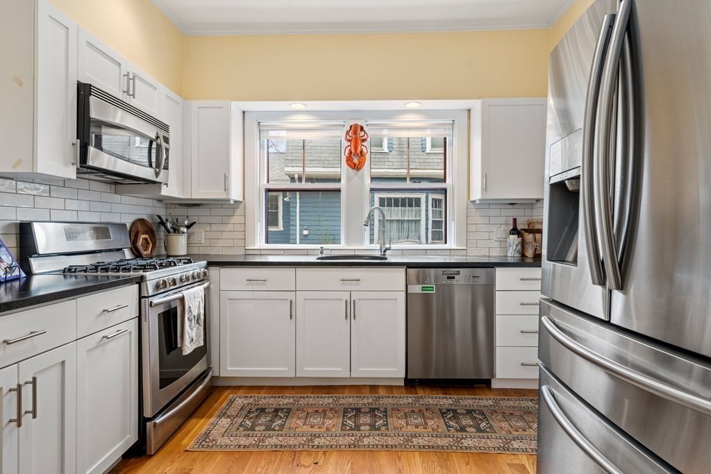 53 Oxford Road Newton, MA 02459 - Photo 11 of 32 a kitchen with stainless steel appliances granite countertop a refrigerator and a stove