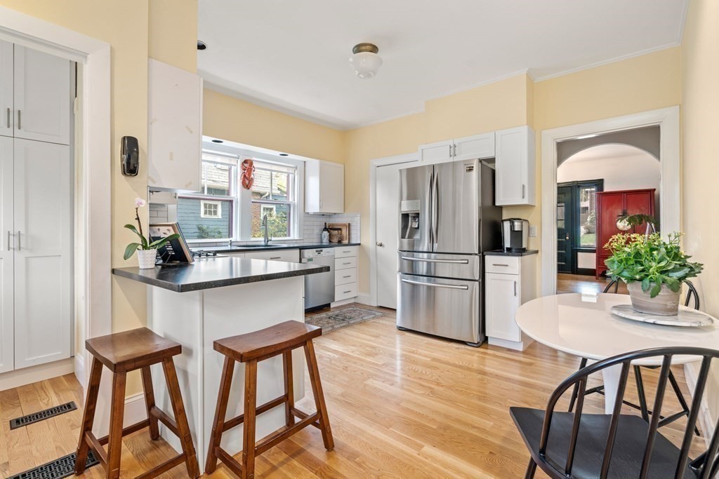 53 Oxford Road Newton, MA 02459 - Photo 12 of 32 a kitchen with stainless steel appliances a refrigerator a stove a dining table and chairs