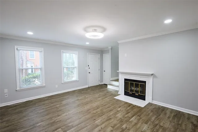 an empty room with windows and fireplace