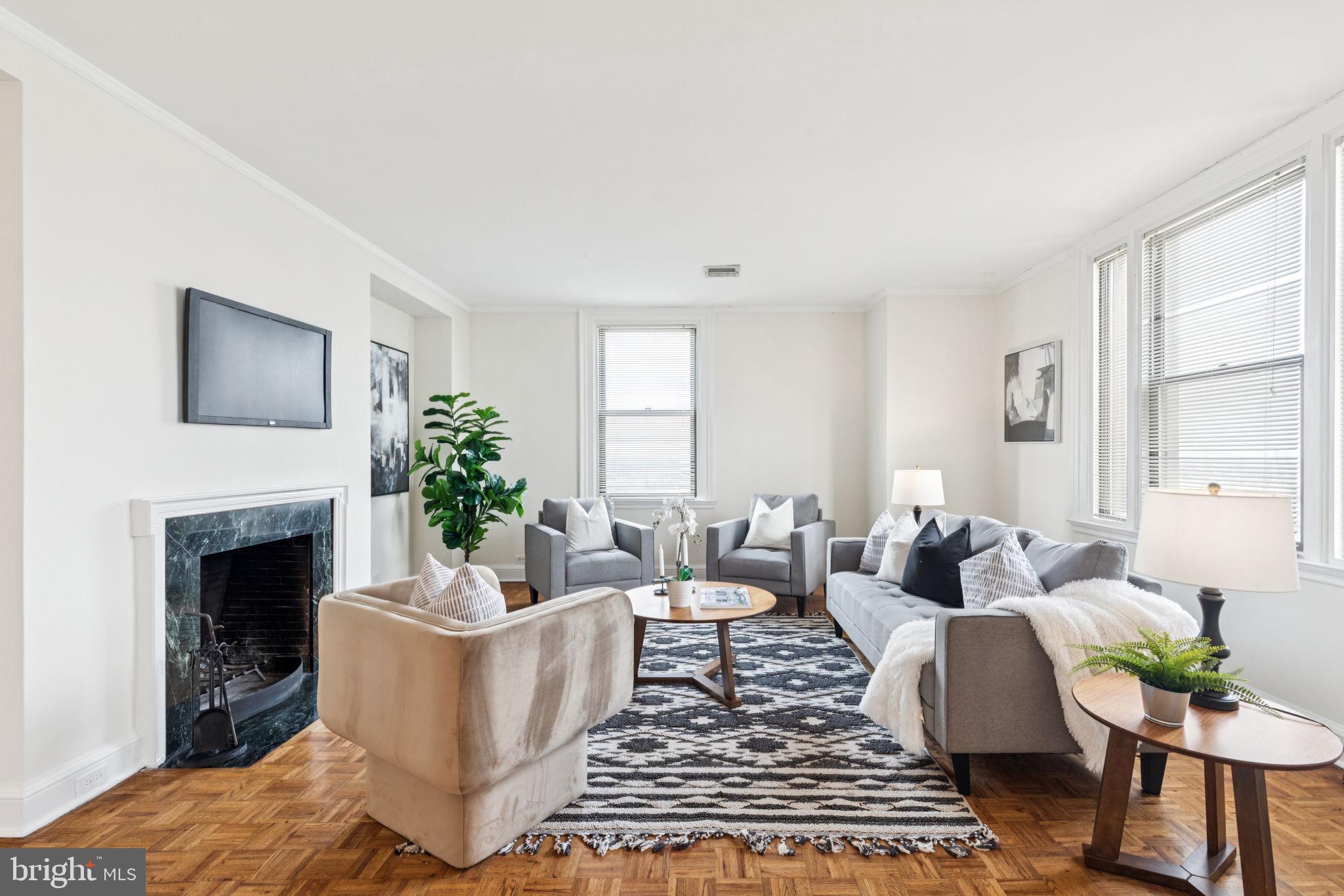 a living room with furniture a fireplace and a window