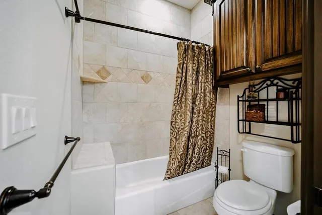 a white toilet sitting next to a bath tub