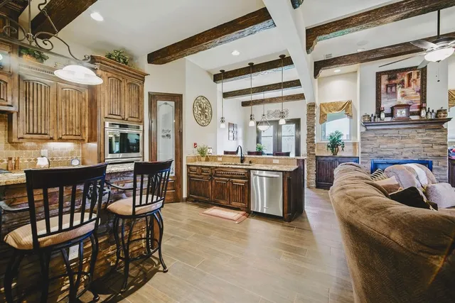 a living room with stainless steel appliances kitchen island granite countertop furniture and a large window