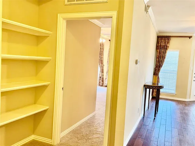 a view of a hallway with wooden floor and furniture