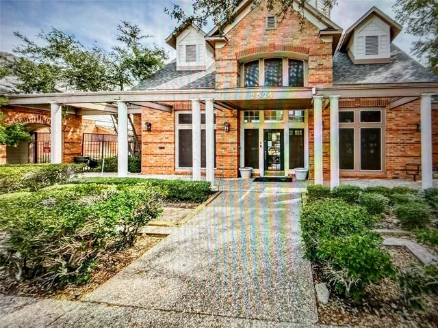 front view of a brick house with a small yard
