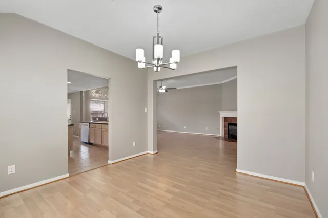 a view of a livingroom with a chandelier fan and windows