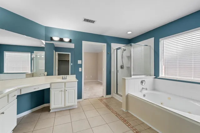 a bathroom with a tub a sink and a large mirror
