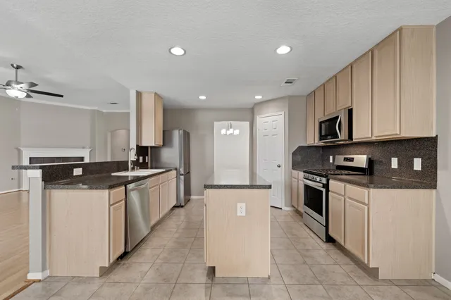 a large kitchen with stainless steel appliances and a sink