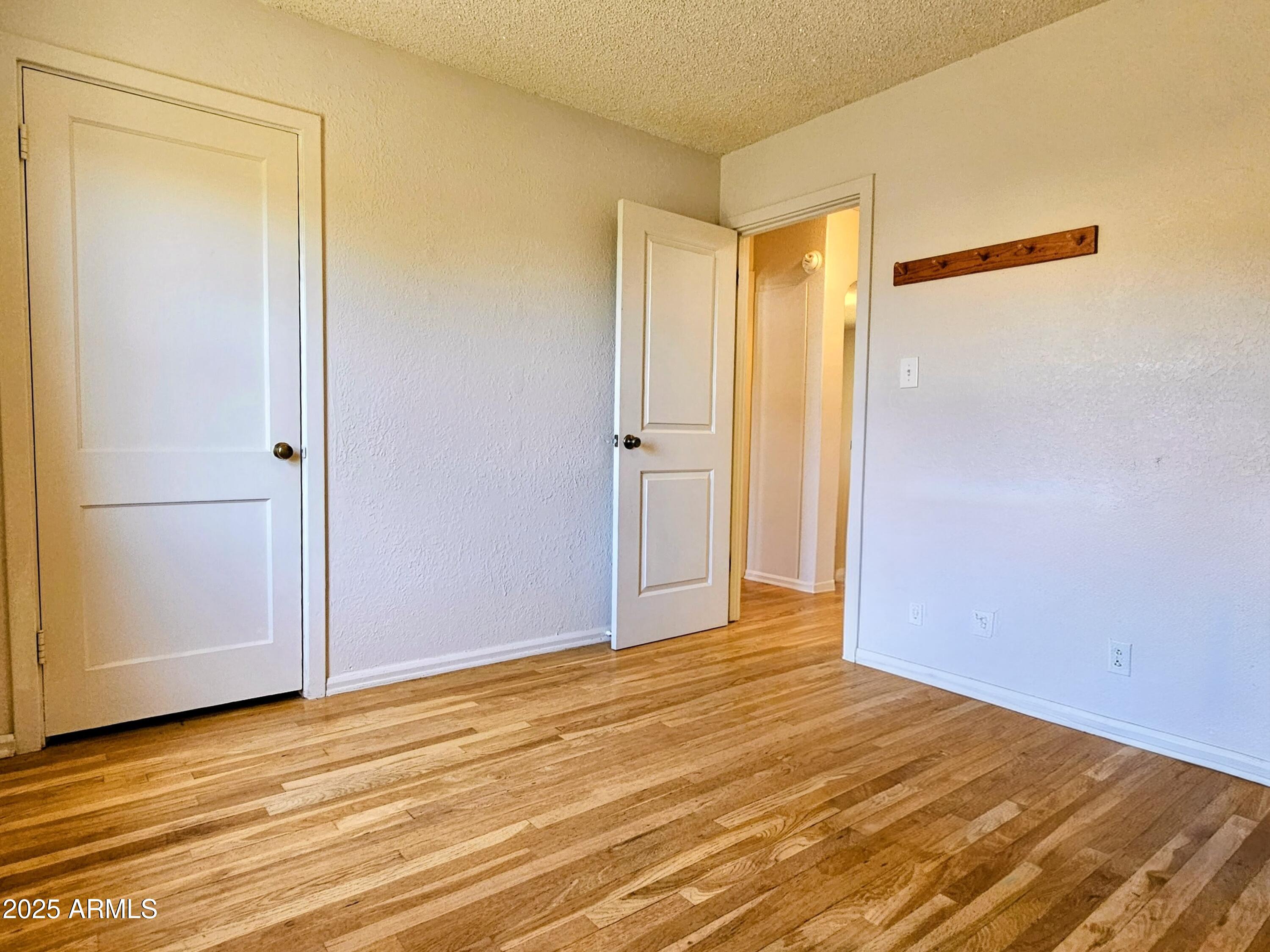 11 Bornite Avenue Bisbee, AZ 85603 - Photo 20 of 28 a view of an empty room with wooden floor and a bathroom
