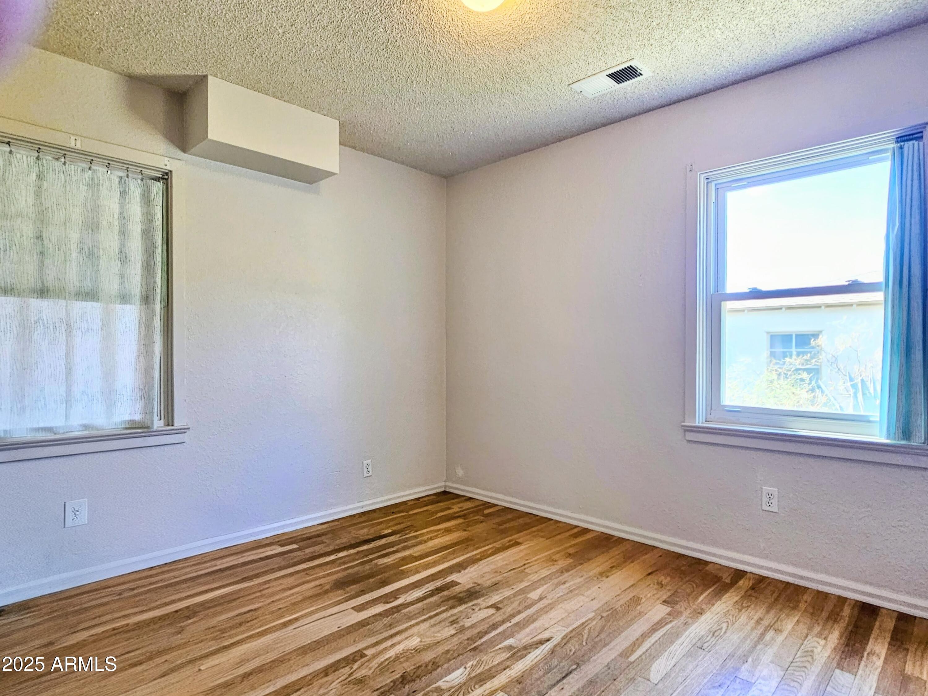 11 Bornite Avenue Bisbee, AZ 85603 - Photo 21 of 28 an empty room with wooden floor and windows