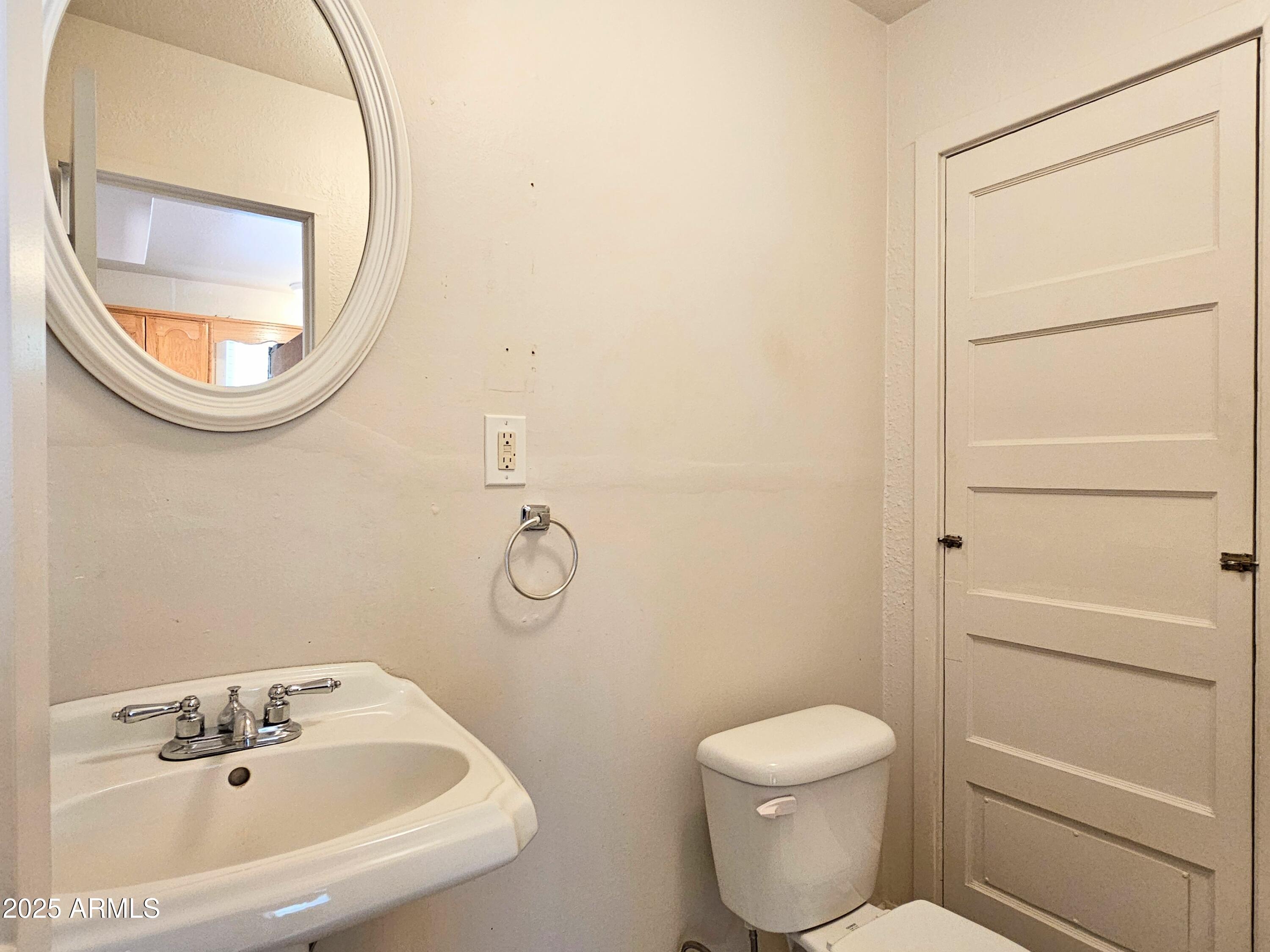 11 Bornite Avenue Bisbee, AZ 85603 - Photo 10 of 28 a bathroom with a sink a toilet and a mirror