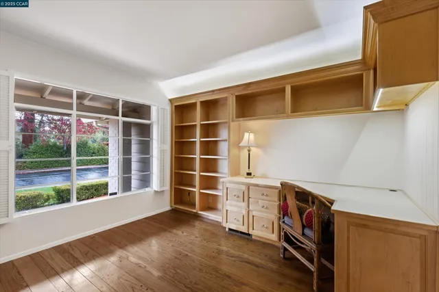 a view of empty room with wooden floor and windows