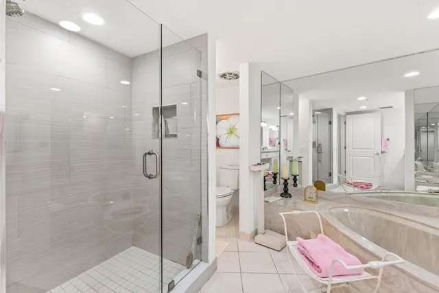 a bathroom with a tub shower and mirror