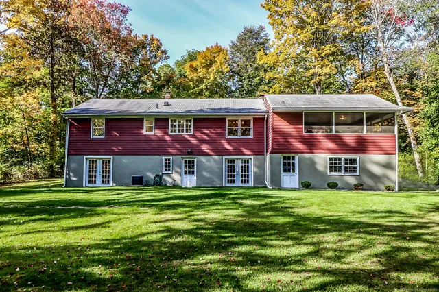 a view of a house with a big yard and large trees