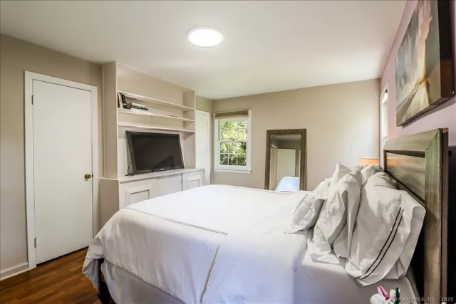 a bedroom with bed and wooden floor