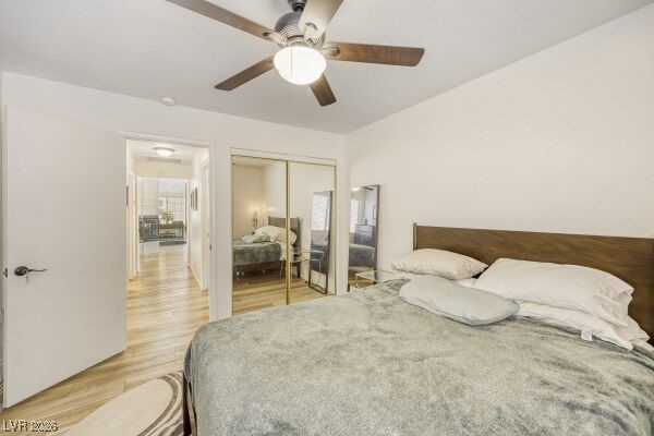1536 Pony Ranch Circle Henderson, NV 89014 - Photo 19 of 23 Bedroom featuring light wood-style floors, ceiling fan, and a closet