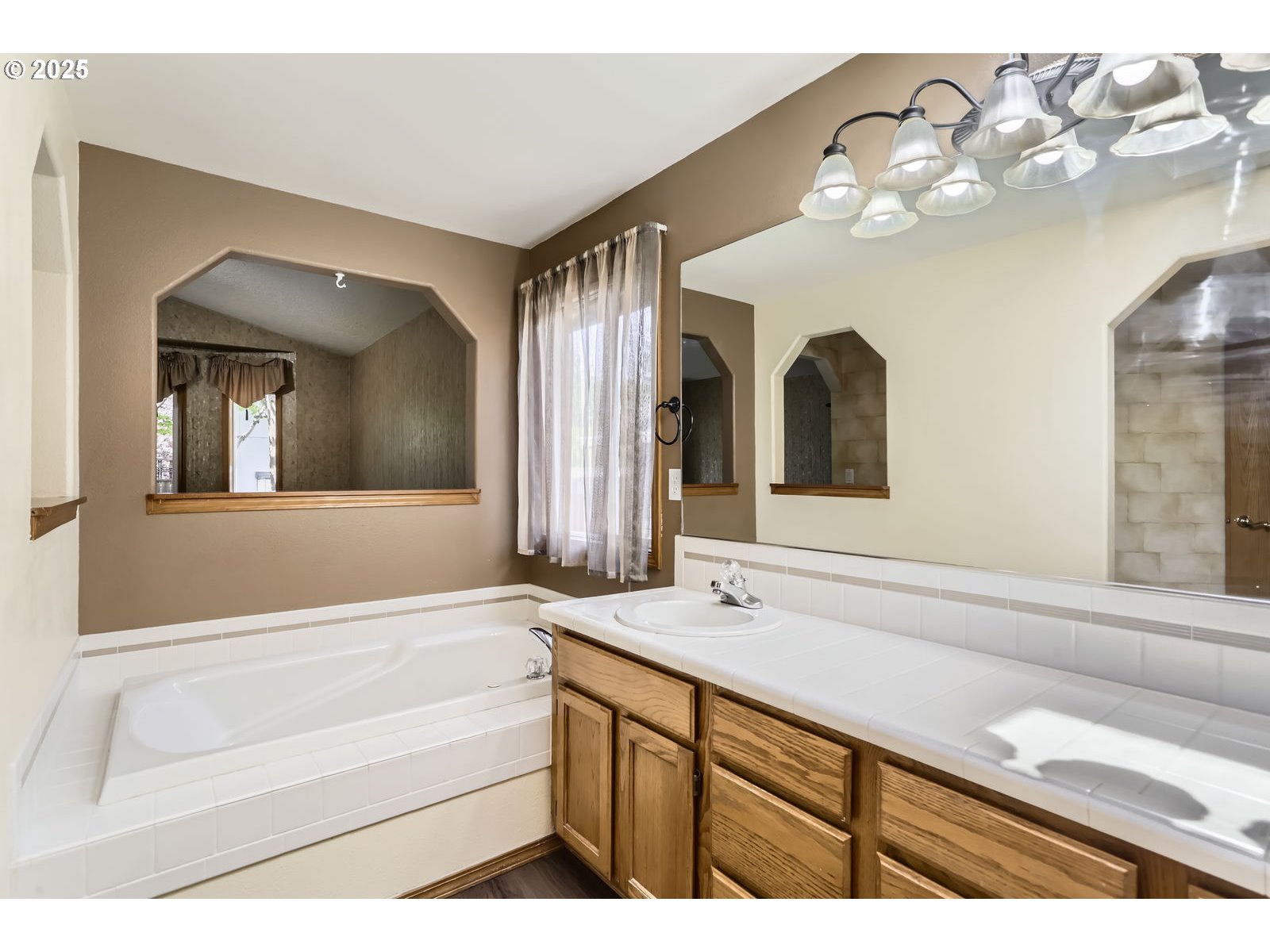 257 Southwest Nancy Circle Gresham, OR 97030 - Photo 20 of 36 a bathroom with a sink a large mirror and a bathtub