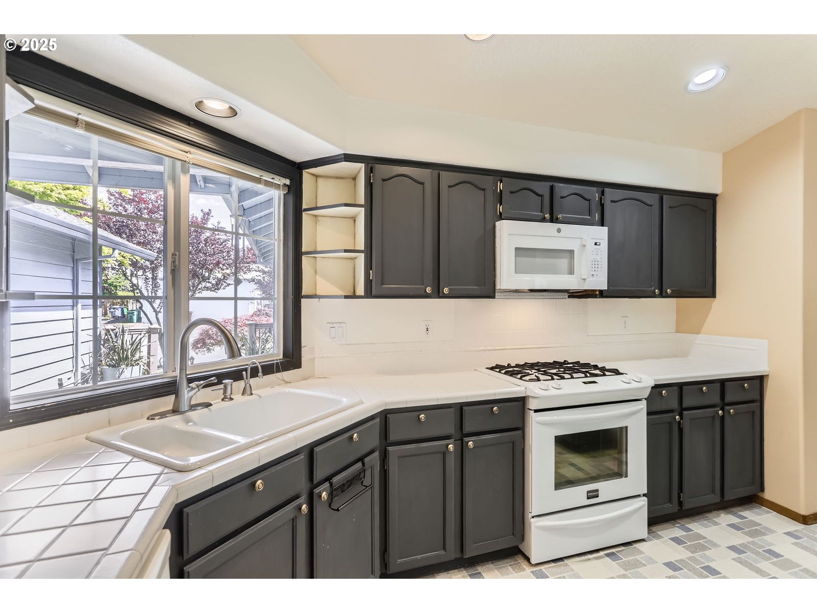 257 Southwest Nancy Circle Gresham, OR 97030 - Photo 10 of 36 a kitchen with a sink stove top oven and cabinets