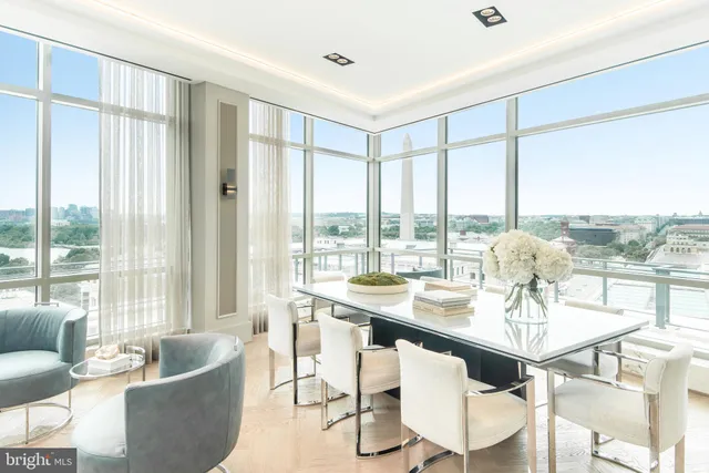 a dining room with furniture a chandelier and wooden floor