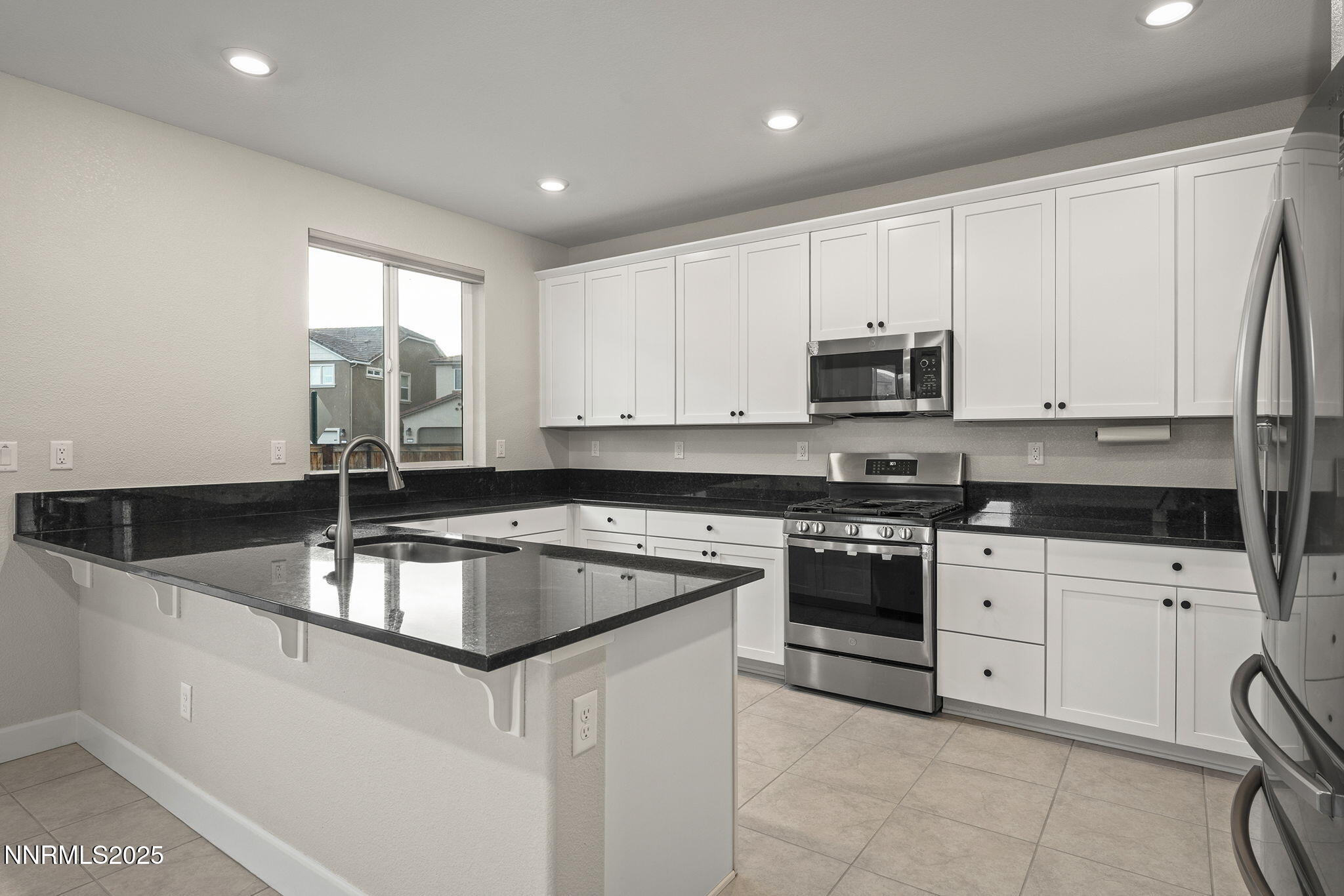 1119 Roswell Road Sparks, NV 89436 - Photo 13 of 35 a kitchen with stainless steel appliances granite countertop a sink a stove and a microwave