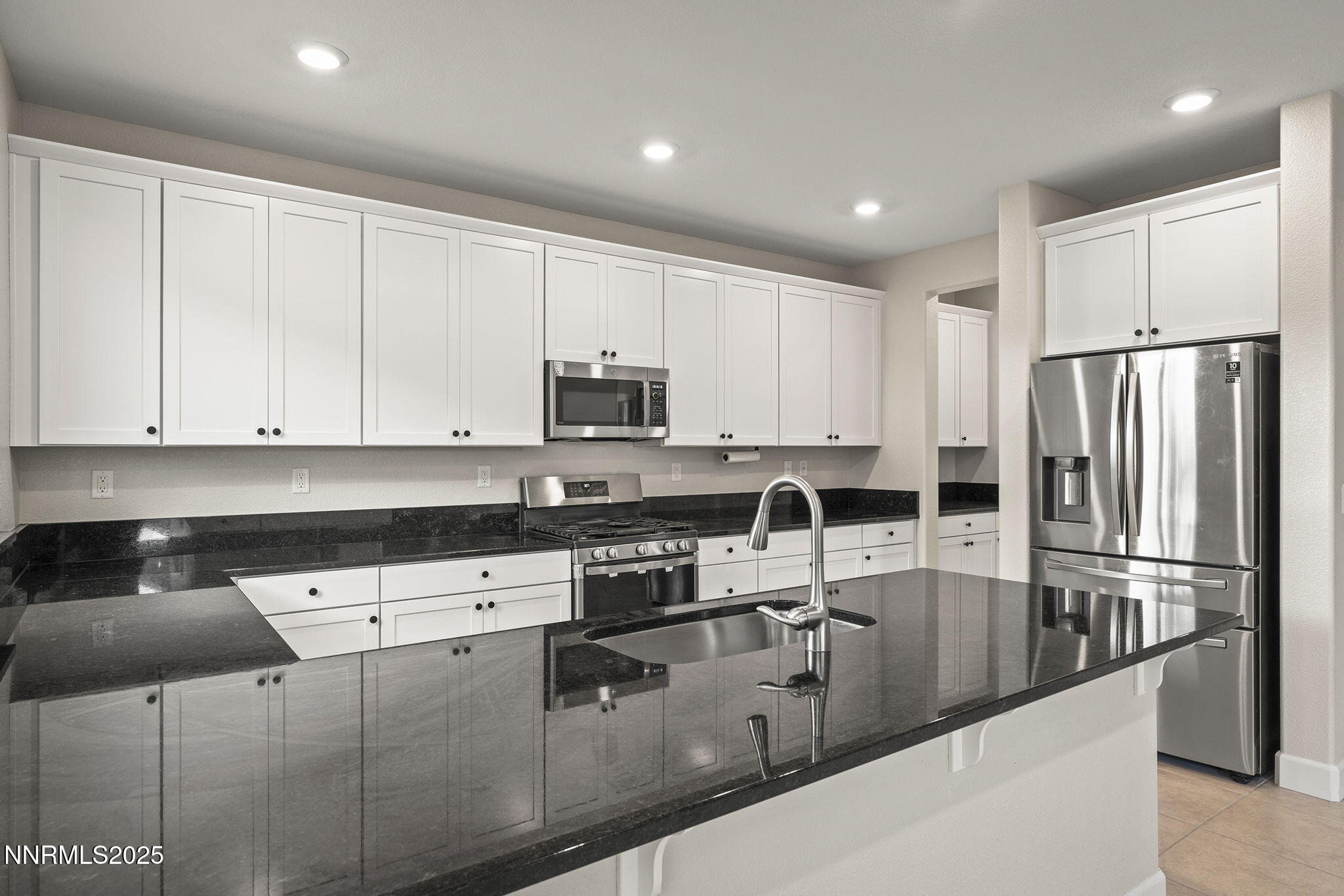 1119 Roswell Road Sparks, NV 89436 - Photo 14 of 35 a kitchen with stainless steel appliances granite countertop a refrigerator sink and white cabinets