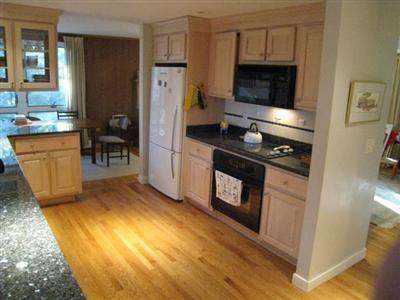 45 Cranberry Hollow Road Wellfleet, MA 02667 - Photo 11 of 26 a kitchen with granite countertop a stove a refrigerator and a wooden cabinets