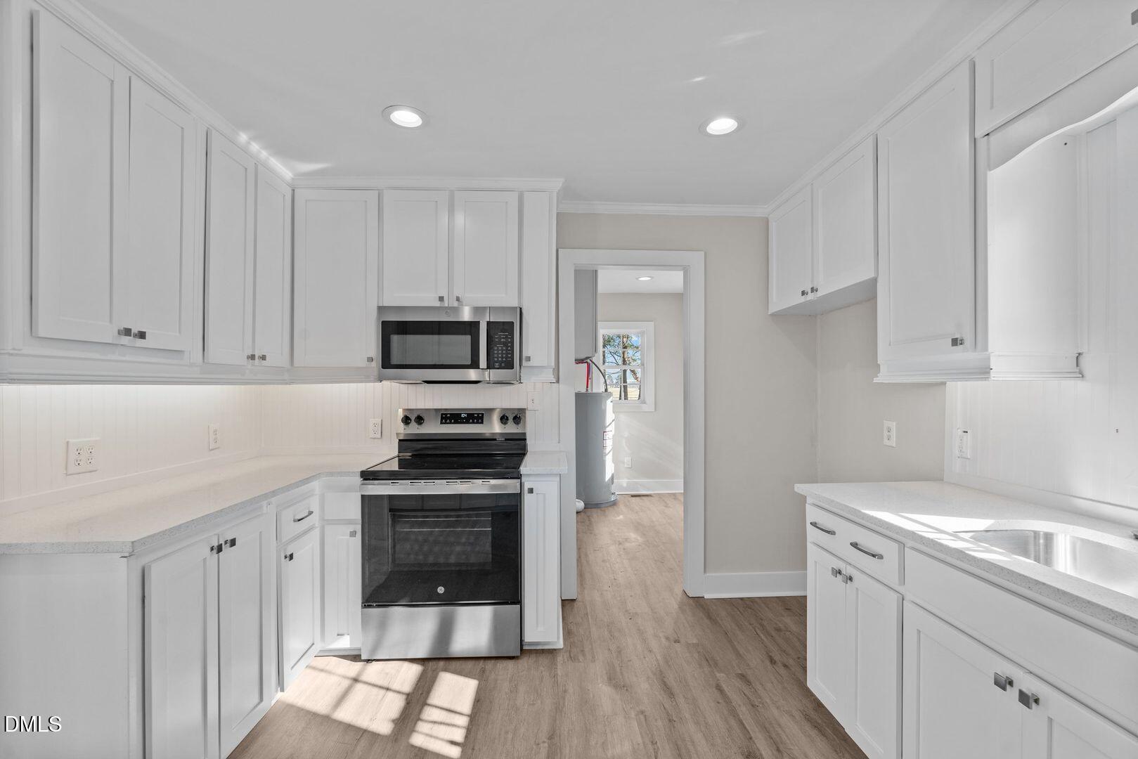 1920 Green Path Road Dunn, NC 28334 - Photo 22 of 30 a kitchen with white cabinets and stainless steel appliances