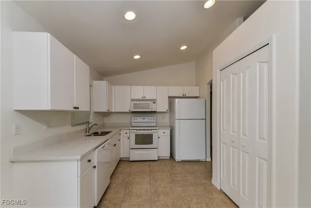 a kitchen with cabinets appliances and a window