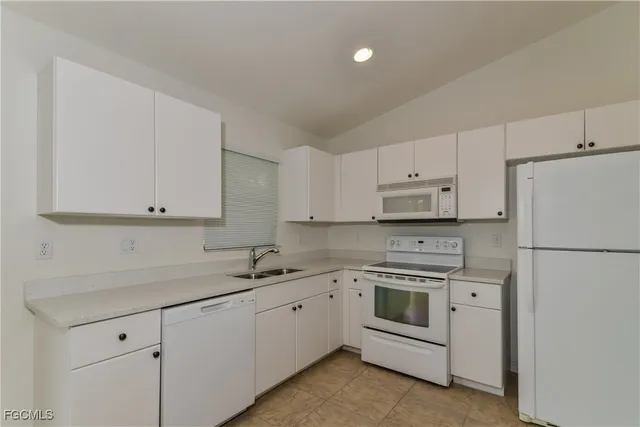 a kitchen with white cabinets and white stainless steel appliances