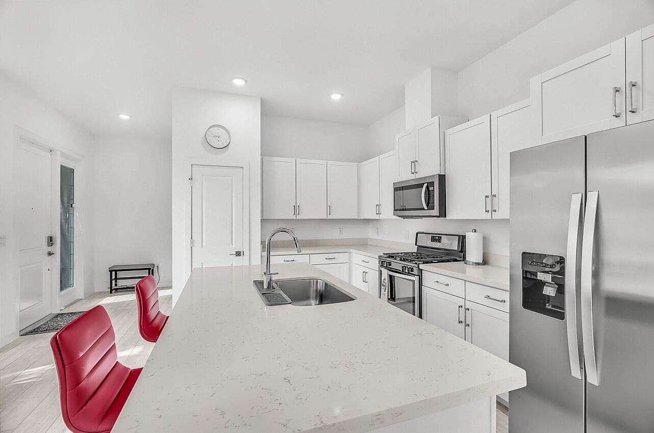 19567 Weathervane Way Loxahatchee, FL 33470 - Photo 11 of 49 a kitchen with stainless steel appliances granite countertop a refrigerator sink stove microwave and stove