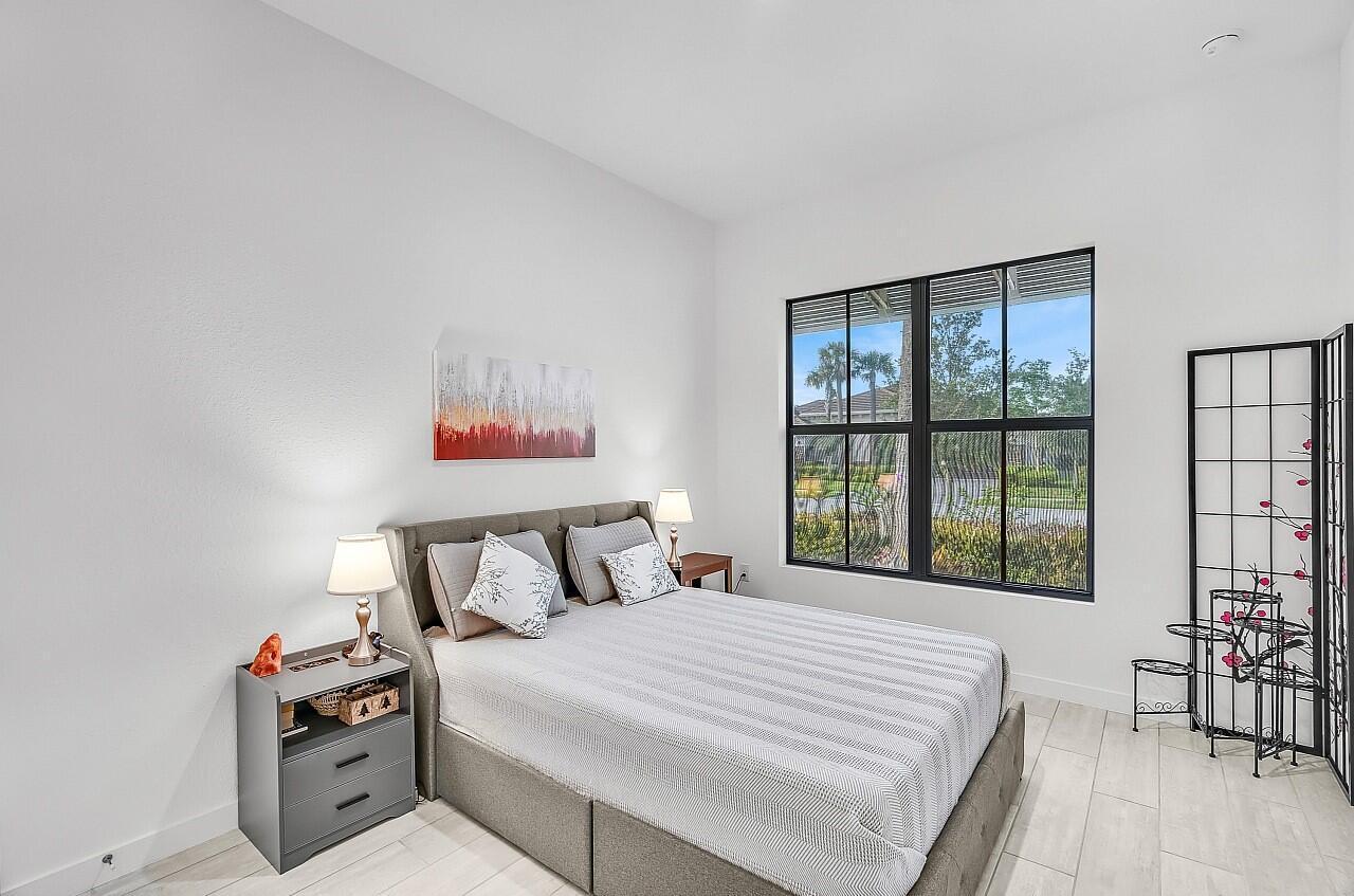 19567 Weathervane Way Loxahatchee, FL 33470 - Photo 19 of 49 a bedroom with a bed and a large window