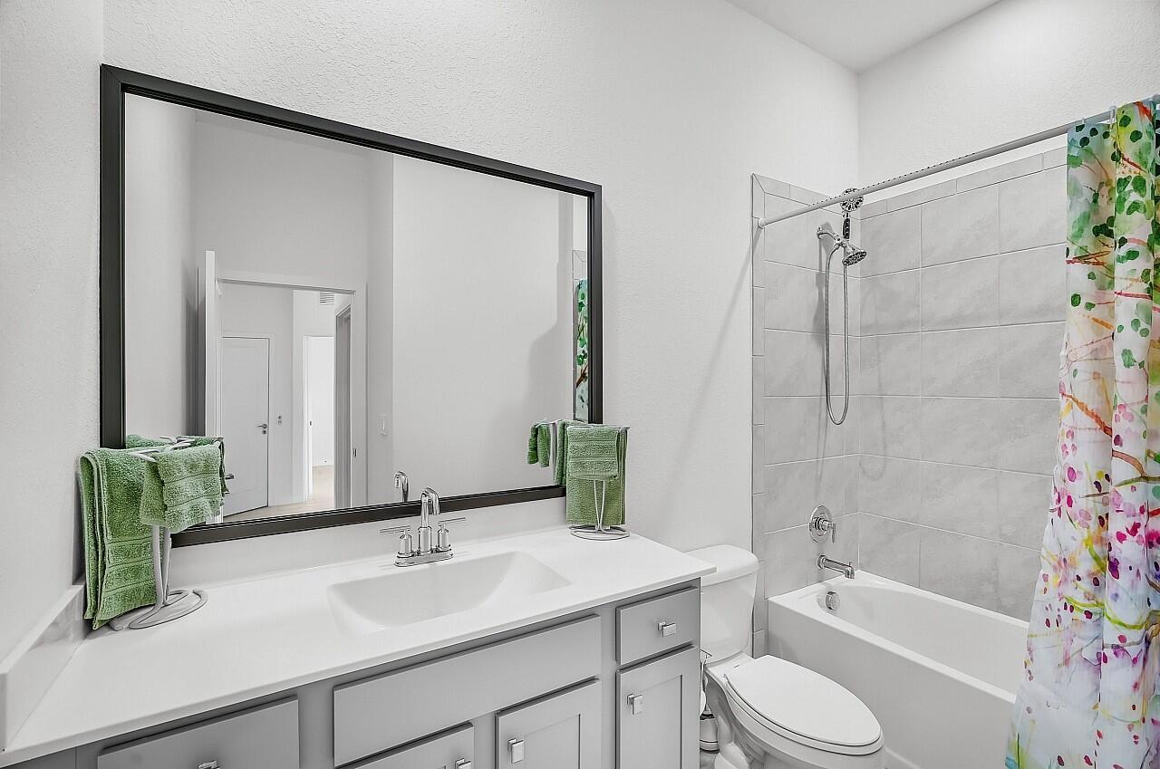 19567 Weathervane Way Loxahatchee, FL 33470 - Photo 21 of 49 a bathroom with a sink a toilet a mirror a bathtub and shower
