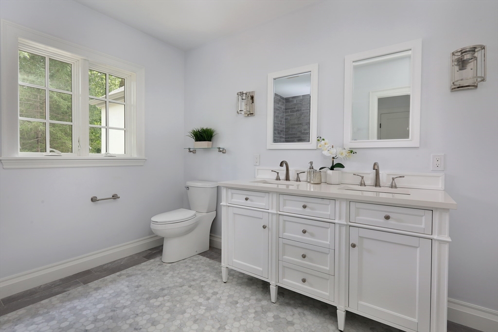 194 Hobart Road Newton, MA 02467 - Photo 25 of 37 a bathroom with a granite countertop toilet a sink and mirror