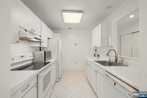 a kitchen with stainless steel appliances granite countertop a sink and refrigerator