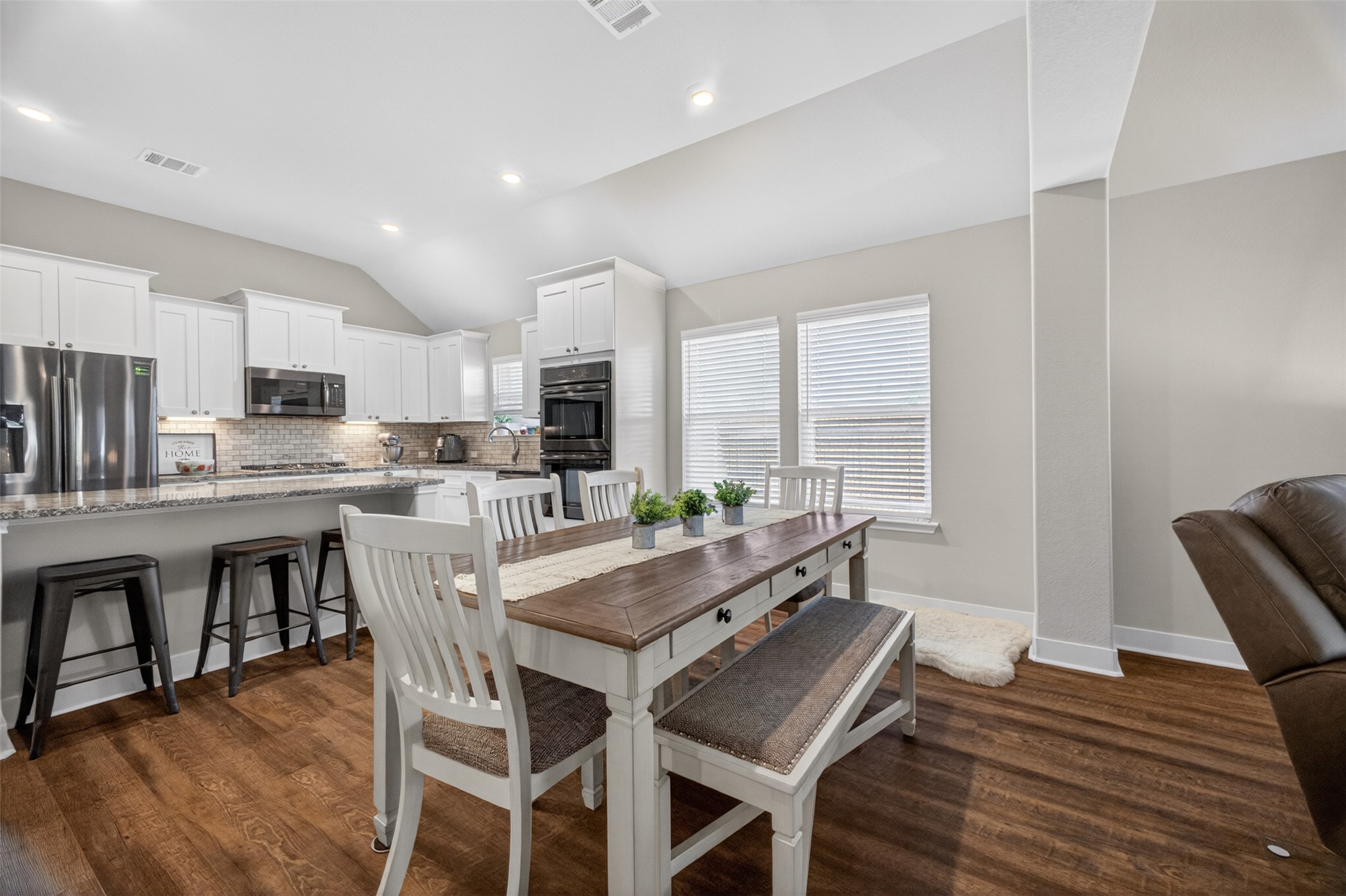1009 Bright Star Cove Georgetown, TX 78628 - Photo 6 of 40 a dining room with kitchen island a stove a table and chairs