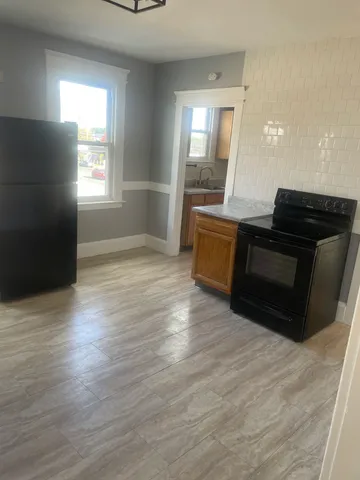 a kitchen with granite countertop a stove and a wooden floors