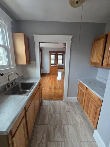 a kitchen with granite countertop wooden floors a sink and a stove