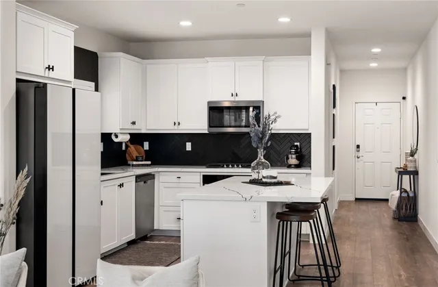 a kitchen with stainless steel appliances a refrigerator sink and white cabinets