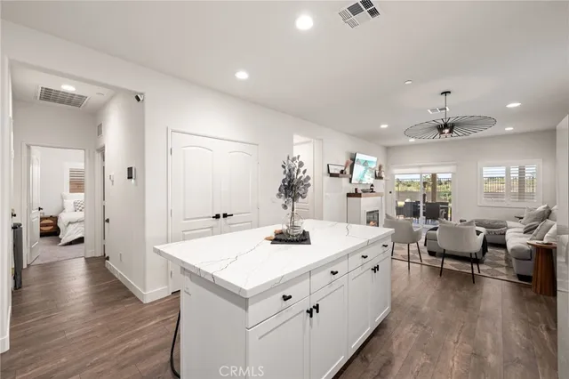 a large white kitchen with a large island oven a sink dishwasher and wooden floor