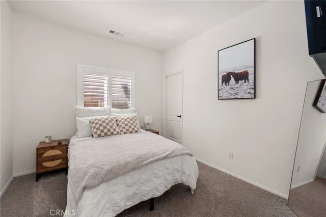 a bedroom with a bed and a painting on the wall