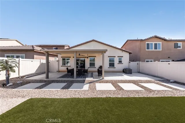 a view of a house with a patio and a yard