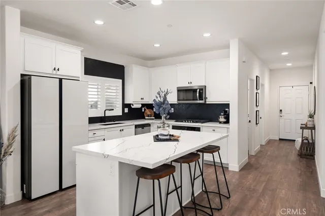 a kitchen with stainless steel appliances a refrigerator and a stove top oven